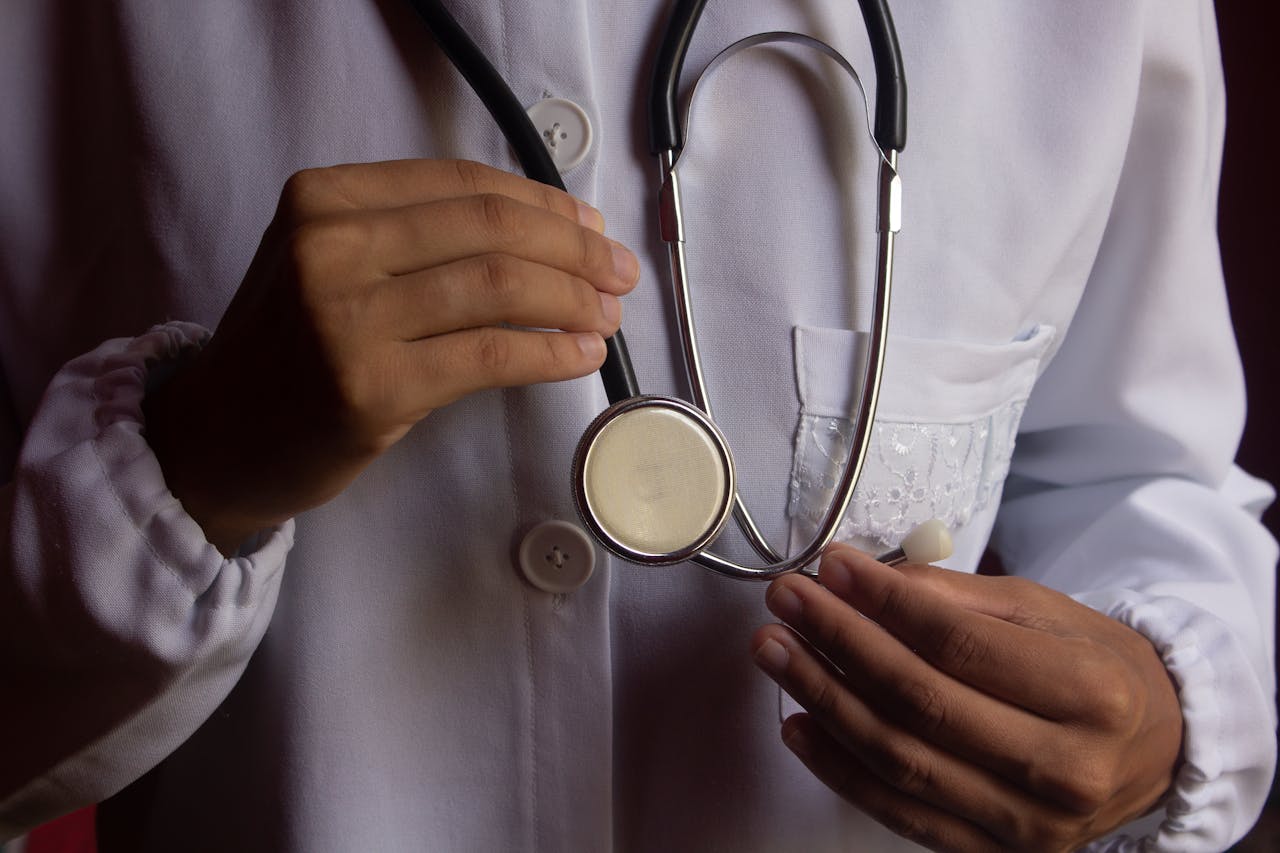 A close-up image of a doctor in a white lab coat holding a stethoscope, symbolizing healthcare.